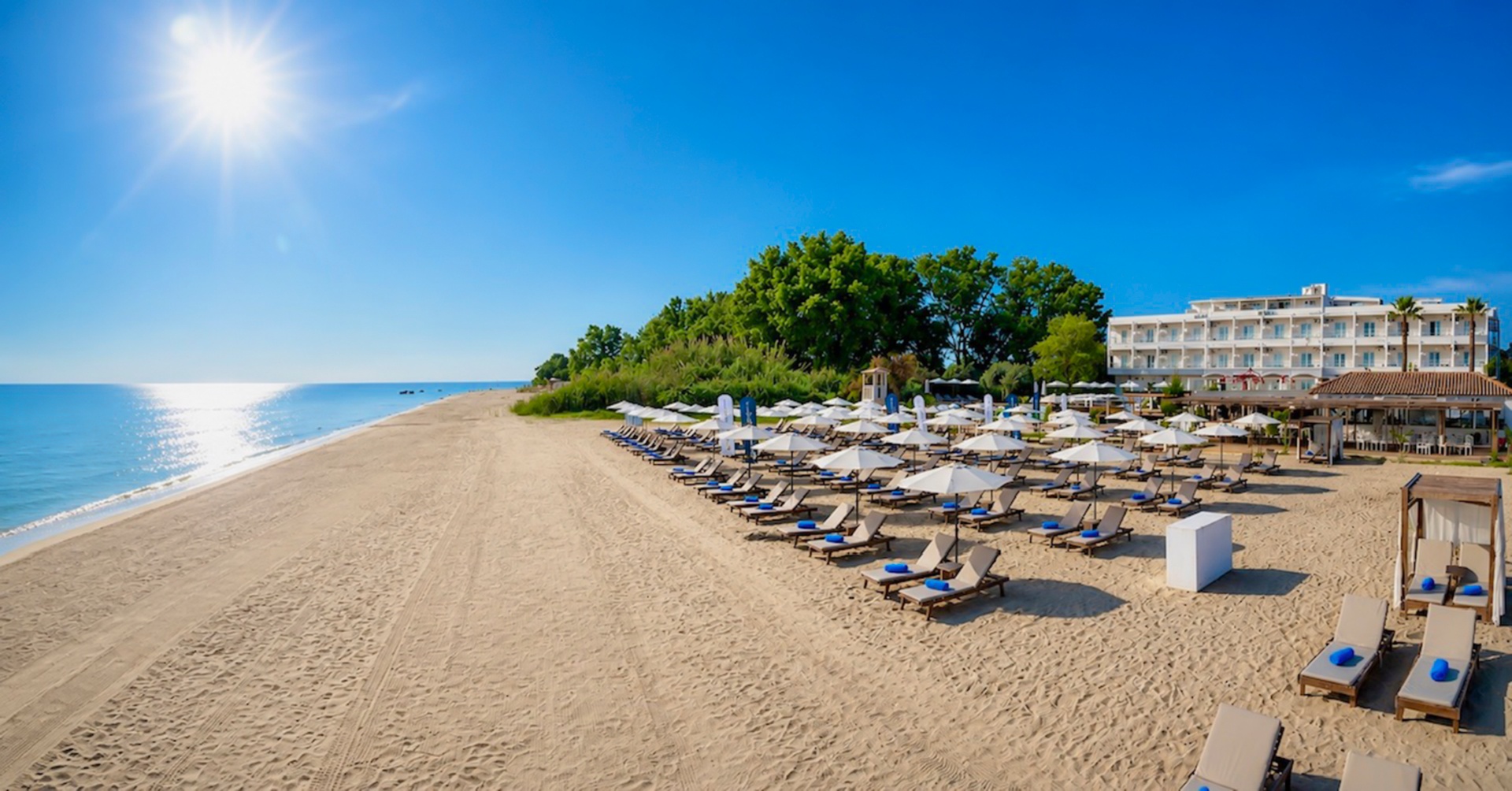 Cavomarina Beach Hotel private beach with sun loungers and umbrellas